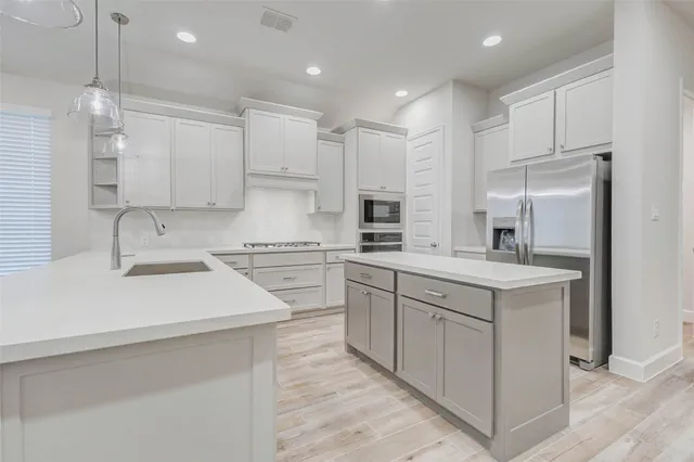 a kitchen with white cabinets appliances and a sink