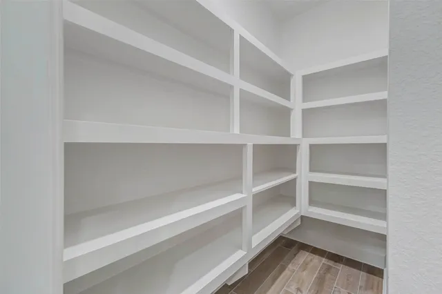 a view of walk in closet with empty racks