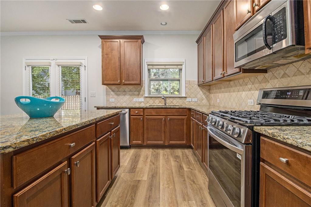 218 Third Avenue Avondale Estates, GA 30002 - Photo 14 of 26 a kitchen with granite countertop a sink stove and cabinets