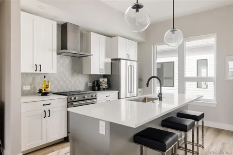 a kitchen with stainless steel appliances a sink a stove a refrigerator and cabinets
