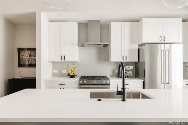 a kitchen with a refrigerator and white cabinets