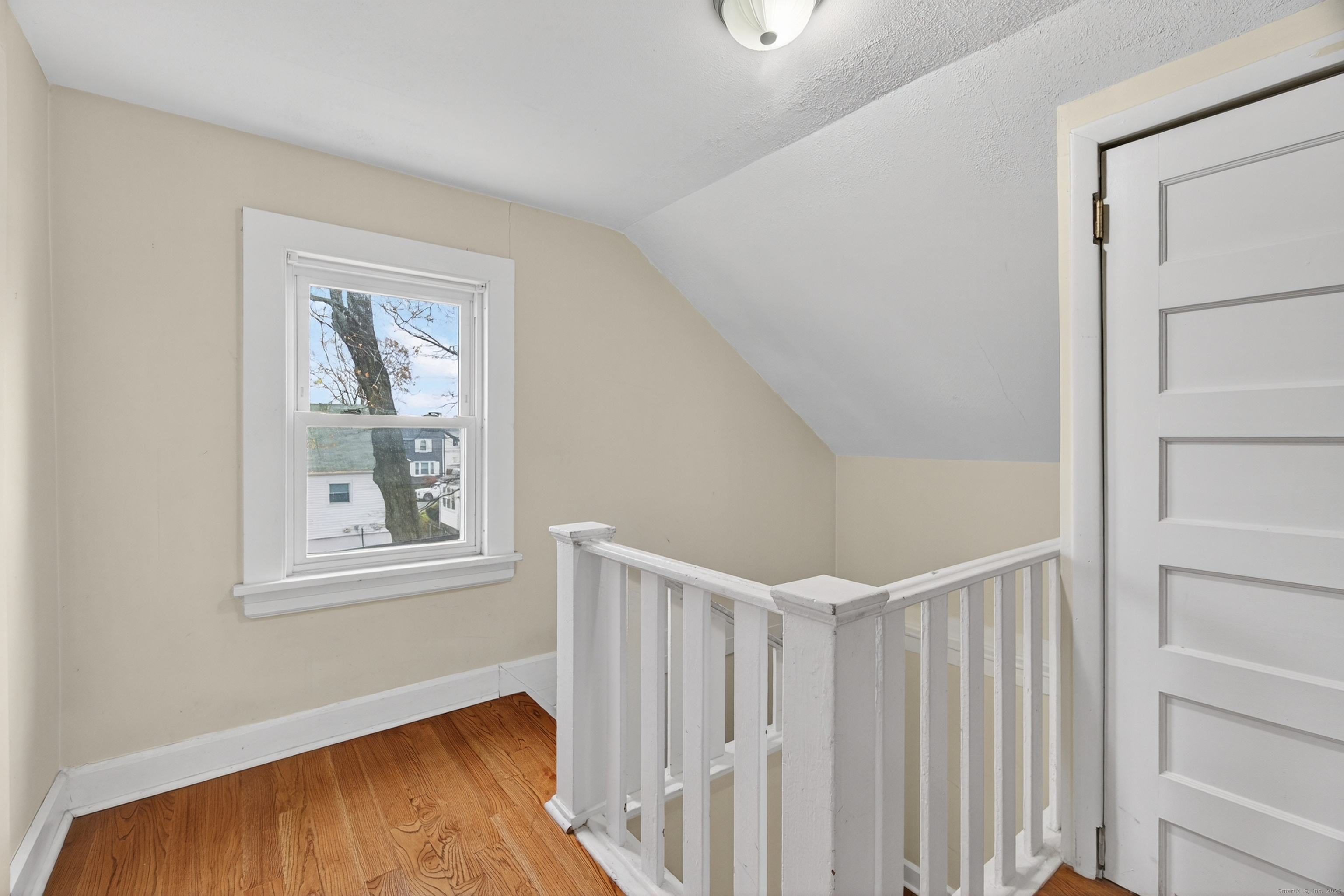 215 Overland Avenue Bridgeport, CT 06606 - Photo 17 of 32 a view of an empty room with a window and wooden floor
