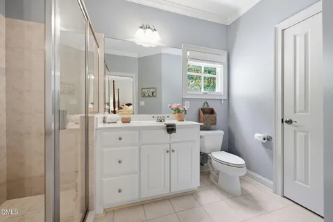 a bathroom with a granite countertop toilet a sink and a mirror