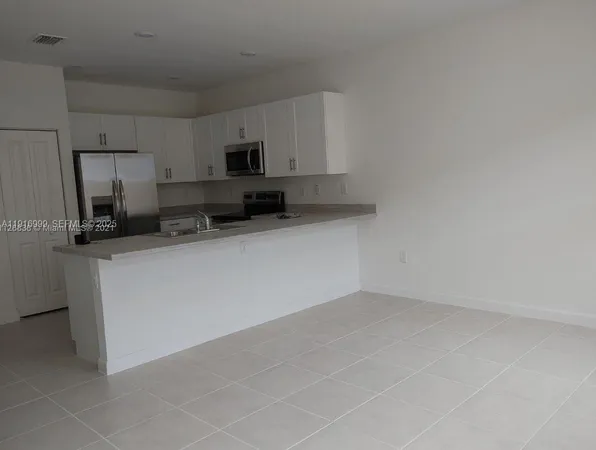 a kitchen with a sink a microwave and cabinets