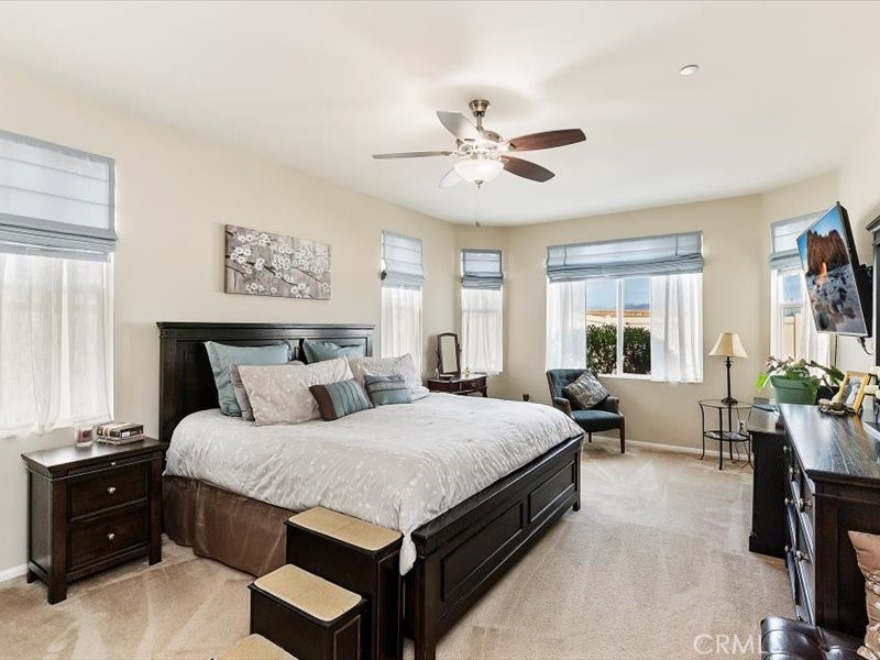 1580 Williamson Park Beaumont, CA 92223 - Photo 22 of 48 a bedroom with a large bed and a chandelier