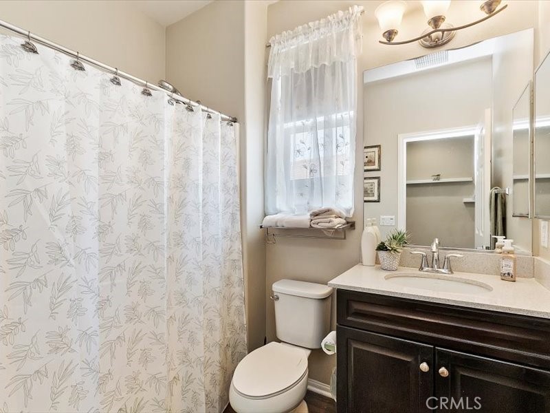1580 Williamson Park Beaumont, CA 92223 - Photo 31 of 48 a bathroom with a sink a toilet a mirror and shower curtain