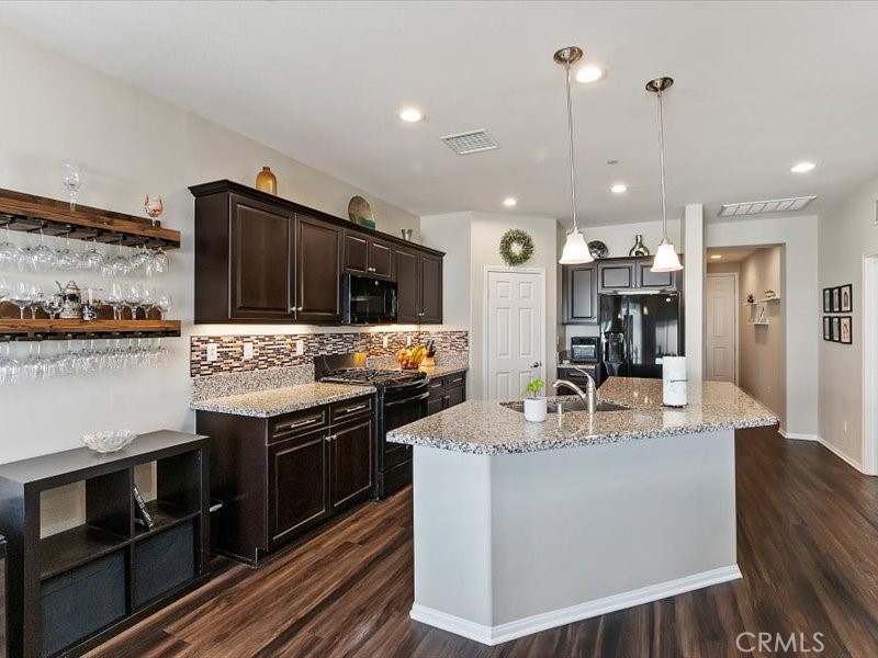 1580 Williamson Park Beaumont, CA 92223 - Photo 8 of 48 a kitchen with stainless steel appliances kitchen island granite countertop a stove and a refrigerator