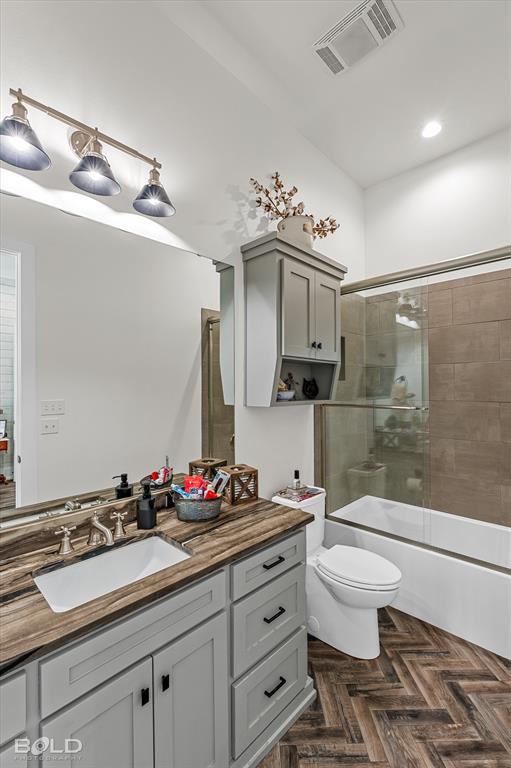 5296 Linton Cutoff Road Benton, LA 71006 - Photo 30 of 40 Bathroom with vanity, parquet floors, and bath / shower combo with glass door