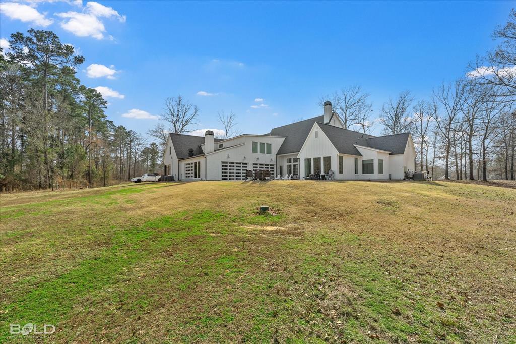 5296 Linton Cutoff Road Benton, LA 71006 - Photo 5 of 40 Rear view of house featuring a chimney and a lawn