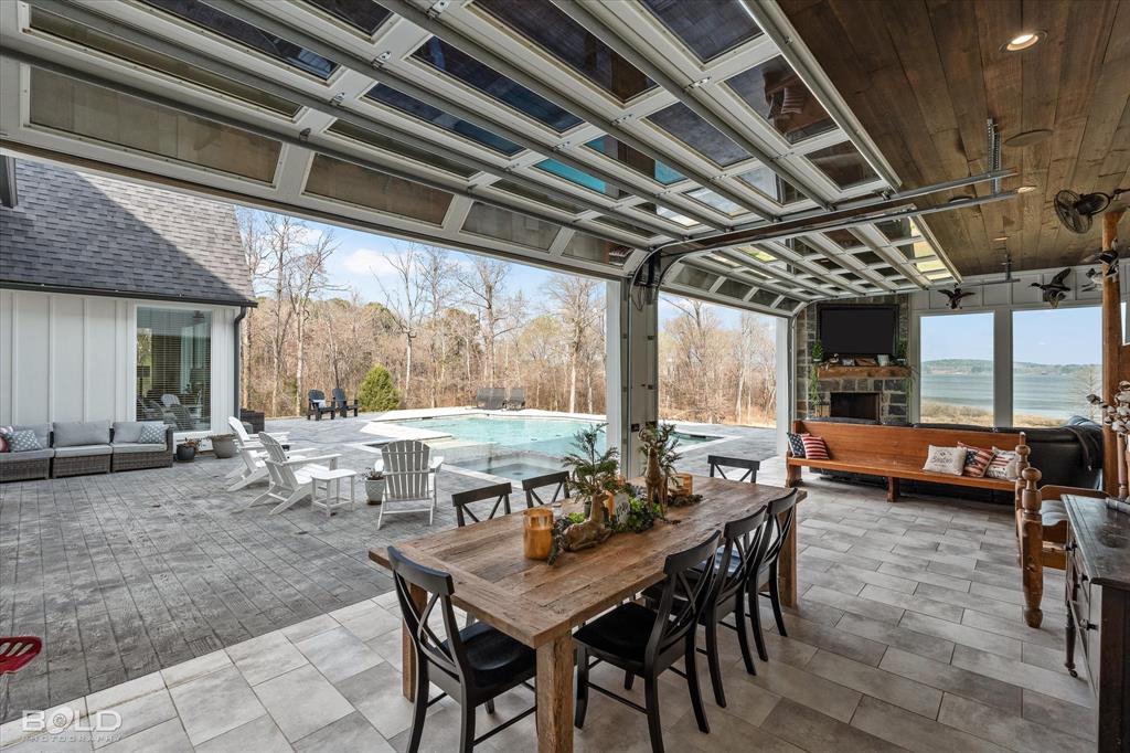 5296 Linton Cutoff Road Benton, LA 71006 - Photo 9 of 40 View of patio / terrace with an outdoor stone fireplace, an outdoor living / dining area, and an outdoor pool