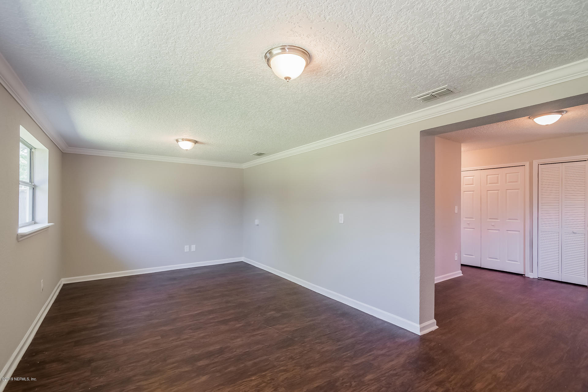 4527 Barnes Road South Jacksonville, FL 32207 - Photo 3 of 25 a view of an empty room with wooden floor and a window