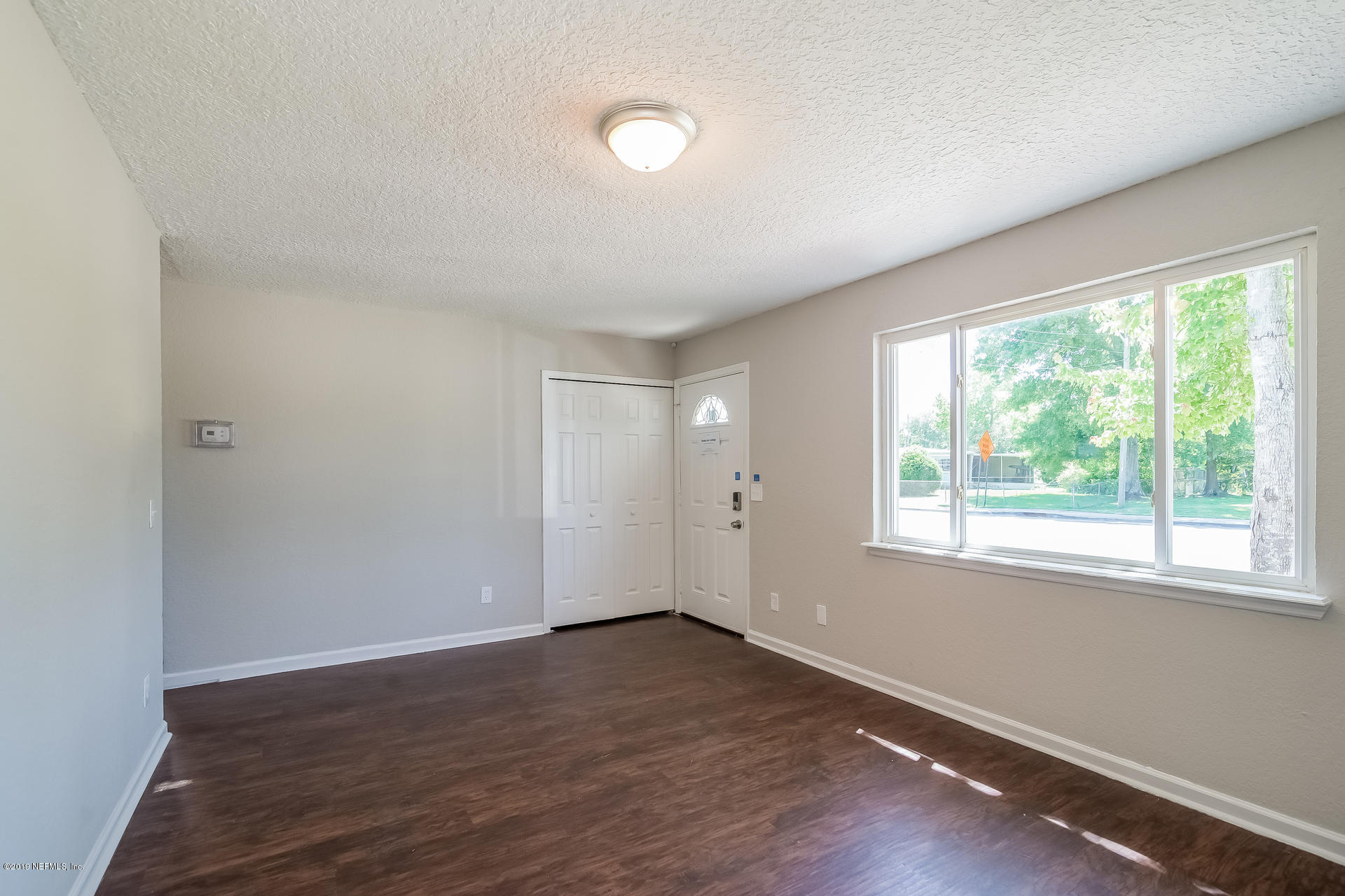 4527 Barnes Road South Jacksonville, FL 32207 - Photo 6 of 25 an empty room with wooden floor and windows