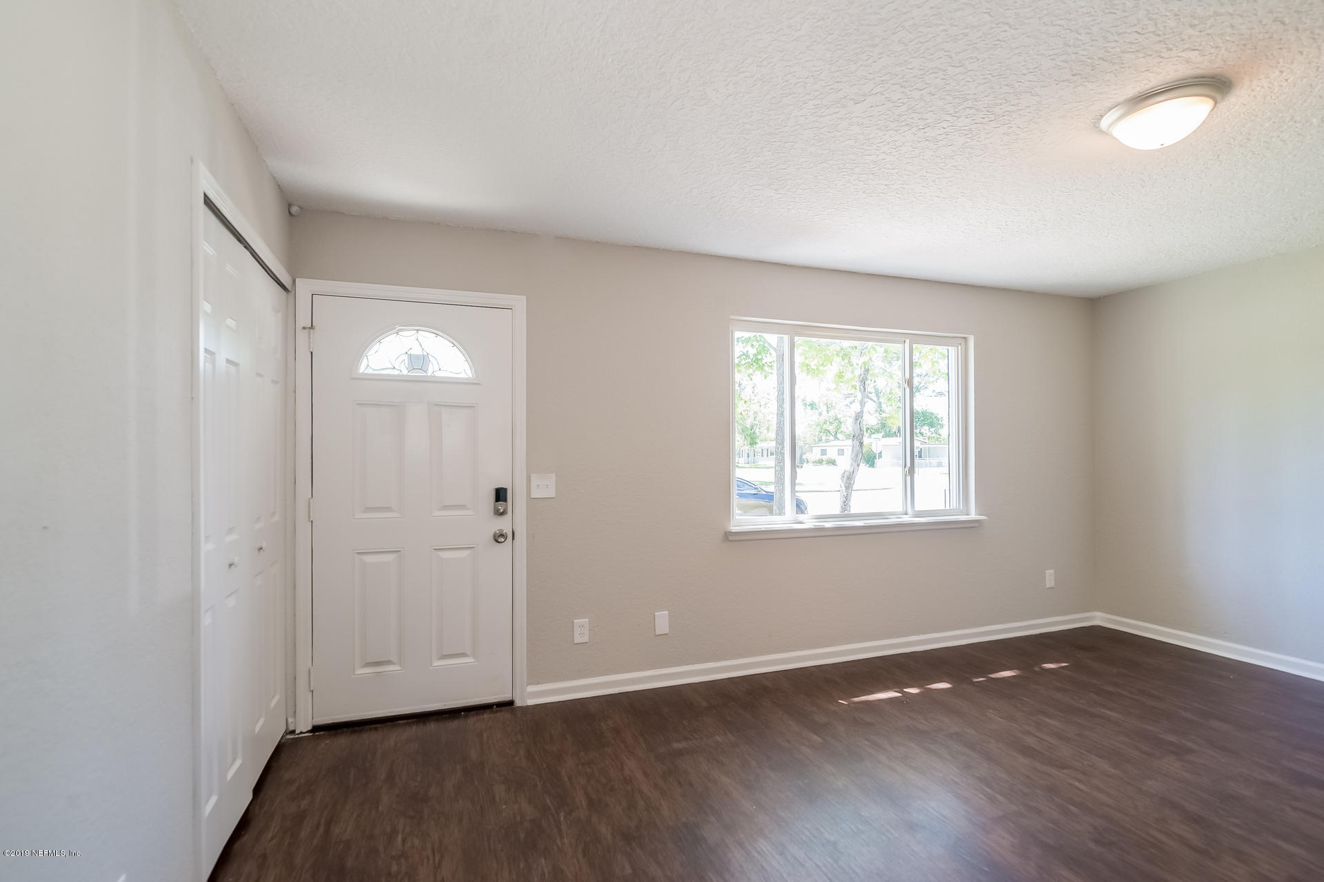 4527 Barnes Road South Jacksonville, FL 32207 - Photo 7 of 25 a view of an empty room with wooden floor and a window