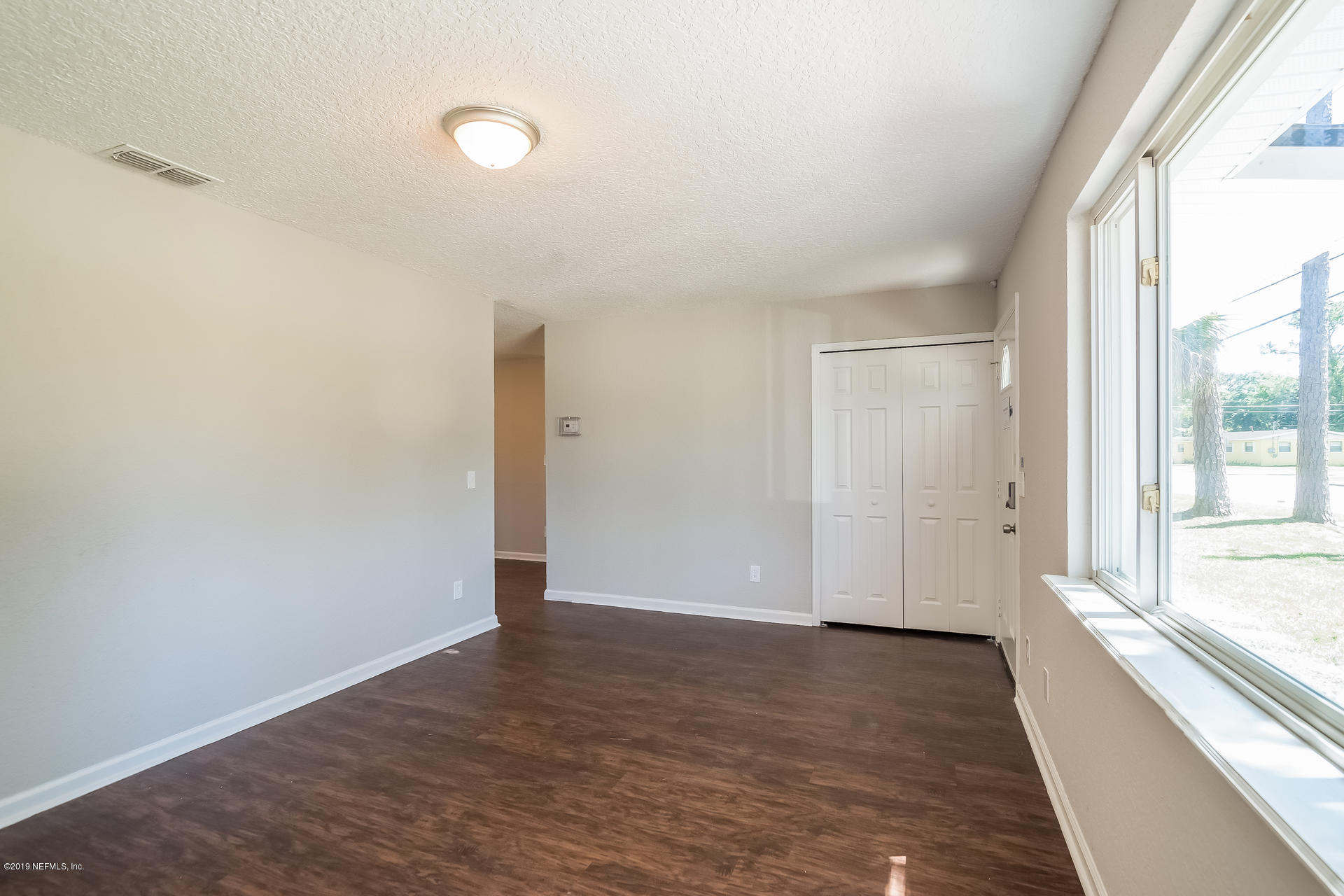 4527 Barnes Road South Jacksonville, FL 32207 - Photo 8 of 25 a view of an empty room with wooden floor and a window