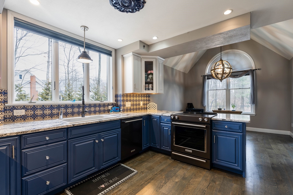 11 Pope Road Atkinson, NH 03811 - Photo 13 of 42 a kitchen with a stove a sink and a wooden cabinets
