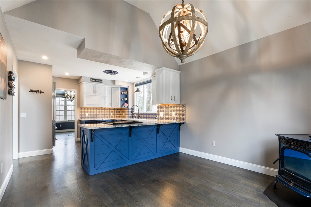 11 Pope Road Atkinson, NH 03811 - Photo 18 of 42 a kitchen with stainless steel appliances a wooden floor and a chandelier