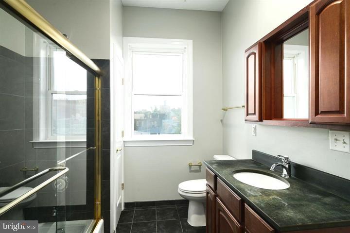 3933 Lancaster Avenue, Unit A Philadelphia, PA 19104 - Photo 16 of 22 a bathroom with a granite countertop sink toilet a mirror and window