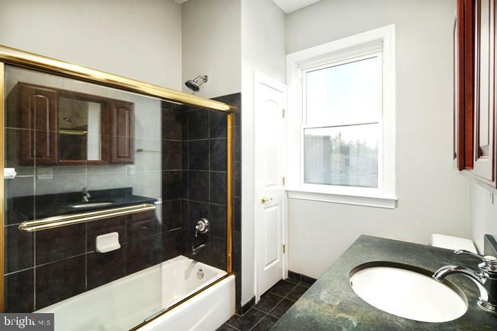 3933 Lancaster Avenue, Unit A Philadelphia, PA 19104 - Photo 17 of 22 a bathroom with a sink a toilet and a shower