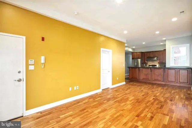 a view of a kitchen with kitchen island wooden floor and living room