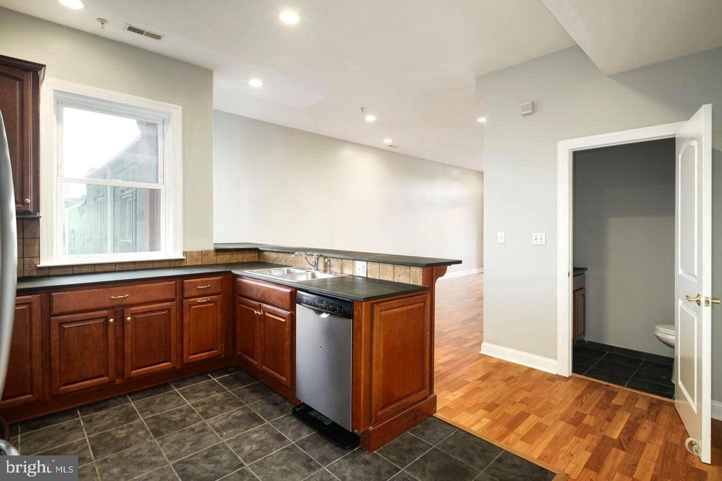 3933 Lancaster Avenue, Unit A Philadelphia, PA 19104 - Photo 5 of 22 a kitchen with stainless steel appliances granite countertop a stove and a sink