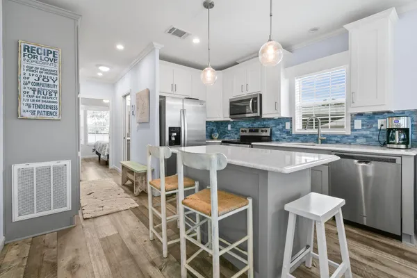 a kitchen with stainless steel appliances granite countertop a stove a sink and a microwave