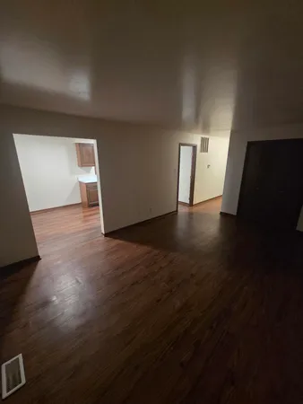 a view of empty room with wooden floor and chair