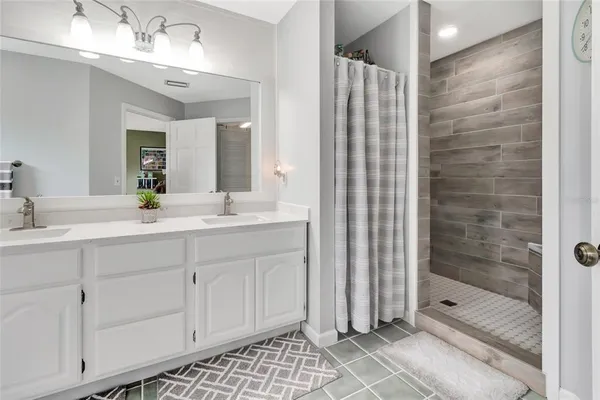 a bathroom with a shower sink and mirror