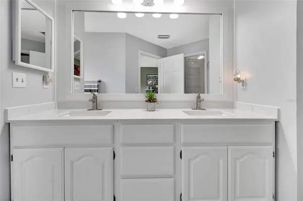 a bathroom with double vanity sink and a mirror
