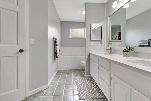 a bathroom with a double vanity sink a toilet and a mirror