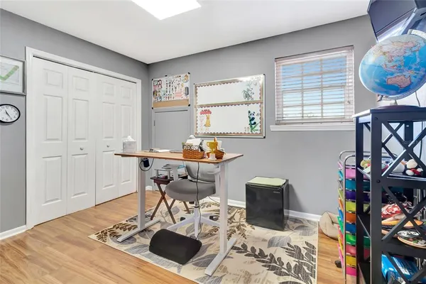 a work room with furniture a rug and a window
