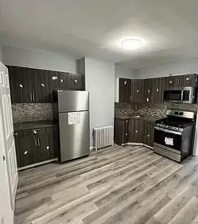 a kitchen with stainless steel appliances granite countertop a refrigerator and a stove top oven