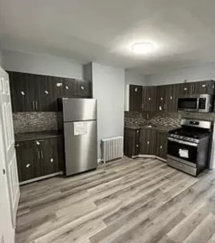 a kitchen with stainless steel appliances granite countertop a refrigerator and a stove top oven