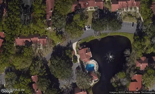 an aerial view of a house with a yard lake and outdoor seating