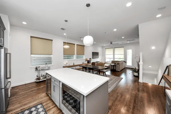 a large kitchen with stainless steel appliances a sink a stove and a wooden floors