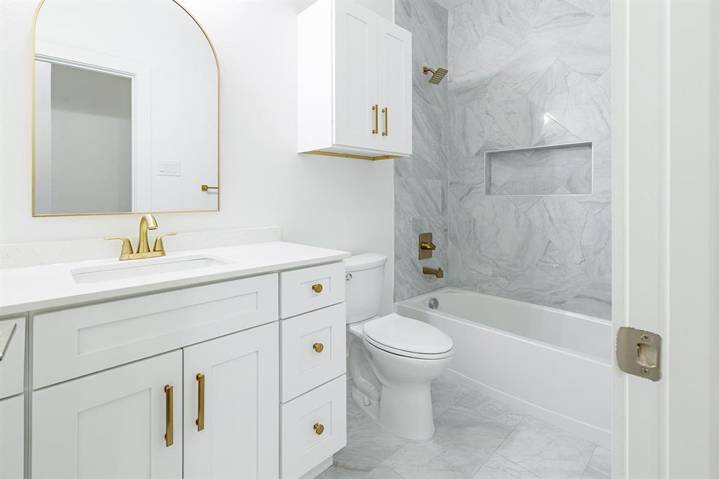 2809 Gooch Street Dallas, TX 75241 - Photo 11 of 19 a bathroom with a sink toilet a mirror and shower