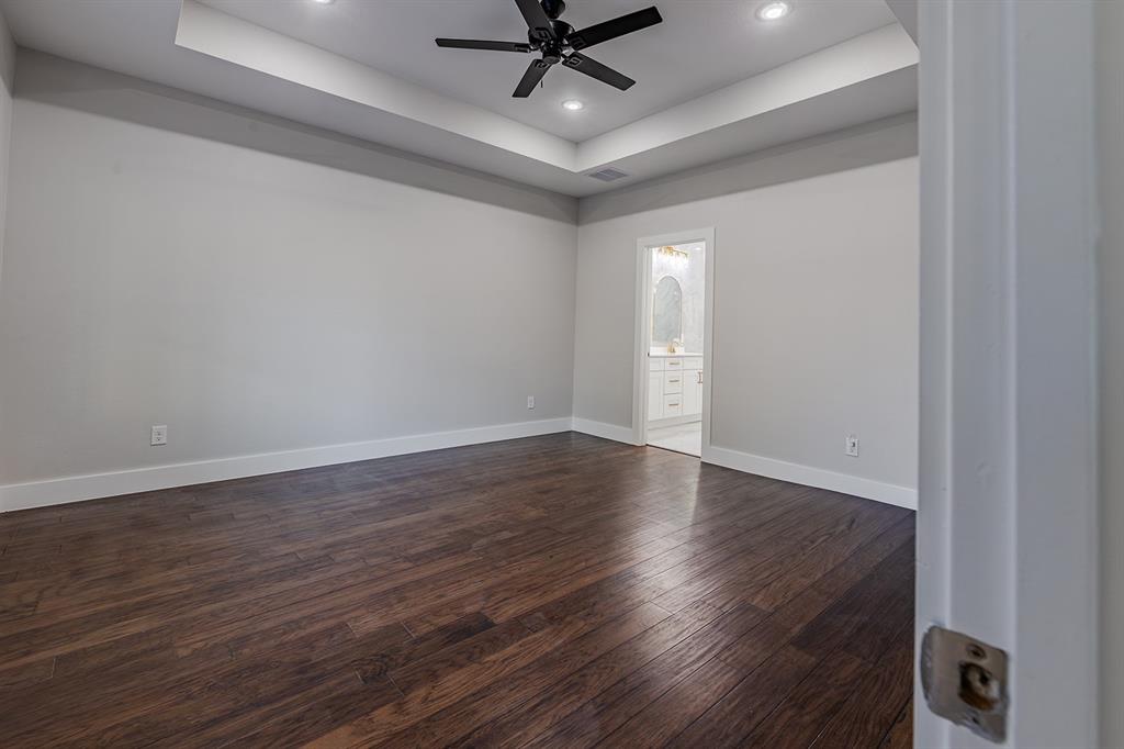 2809 Gooch Street Dallas, TX 75241 - Photo 15 of 19 a view of an empty room with wooden floor and a ceiling fan