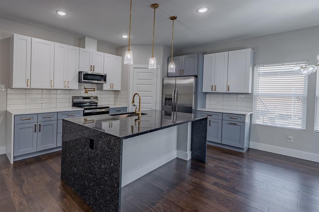 2809 Gooch Street Dallas, TX 75241 - Photo 5 of 19 a kitchen with kitchen island granite countertop a sink cabinets and stainless steel appliances