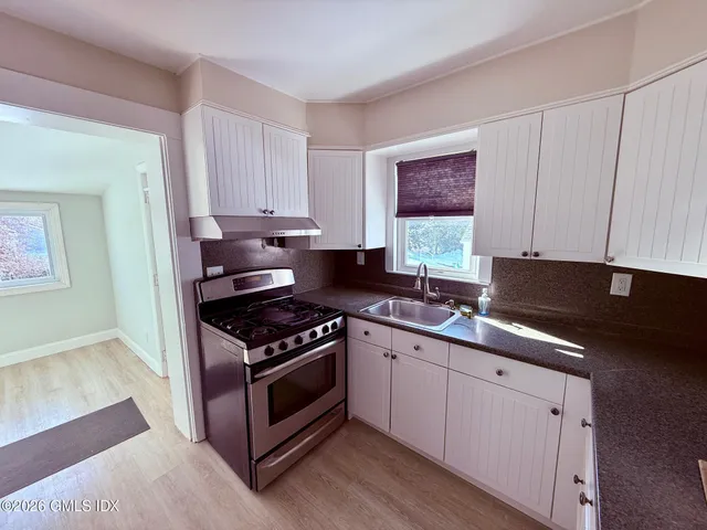 a kitchen with stainless steel appliances granite countertop a stove a sink and a microwave