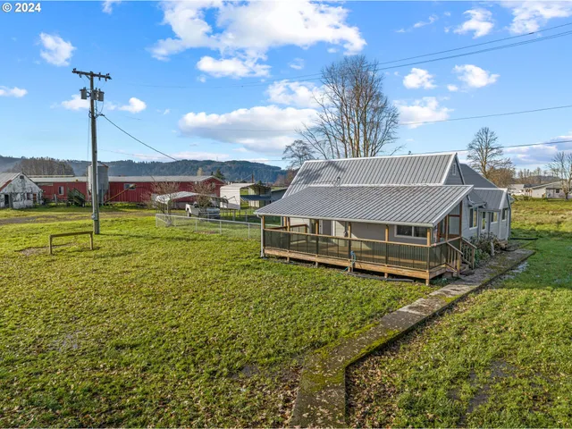 a view of a house with a big yard and a large tree