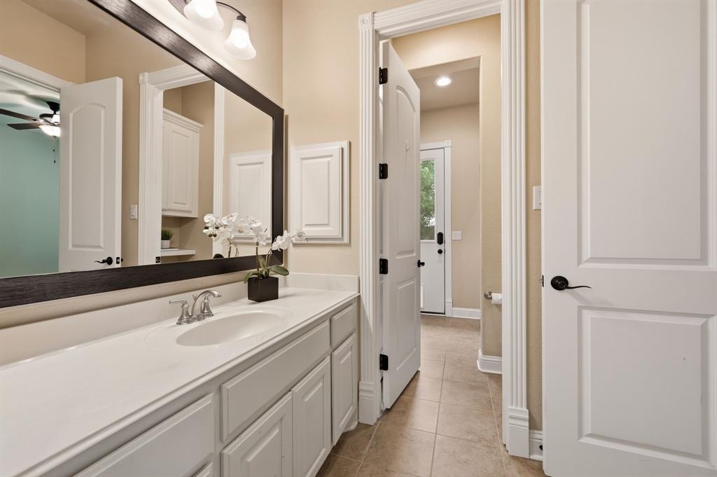 7013 Handel Colleyville, TX 76034 - Photo 24 of 37 Bathroom vanity with a single undermount sink, a chrome-finish faucet, and a large framed mirror with integrated lighting
