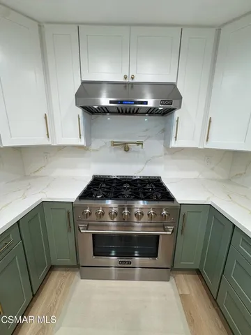 a stove top oven sitting inside of a kitchen