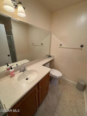 a bathroom with a sink and mirror with toilet