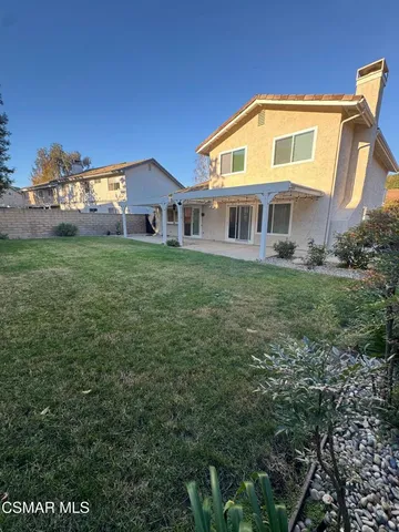 a view of a big house with a big yard and large trees