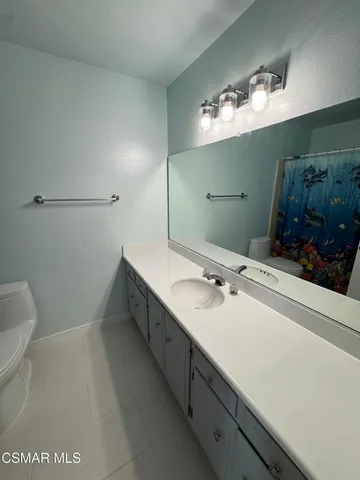 a bathroom with a double vanity sink mirror and toilet