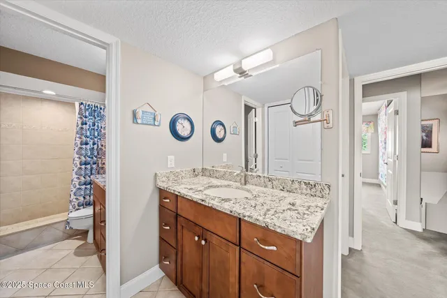a bathroom with a granite countertop sink toilet and shower