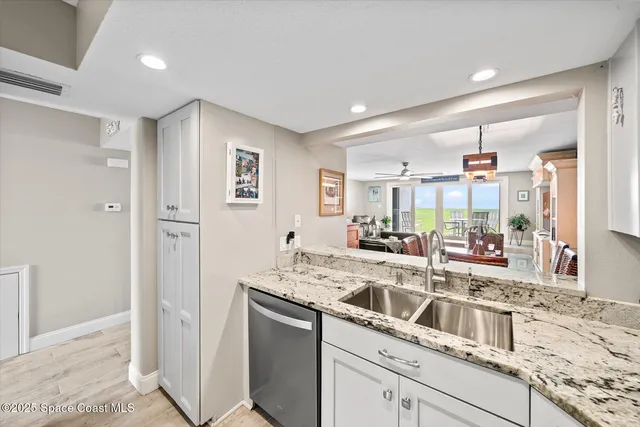 a kitchen with stainless steel appliances granite countertop a sink and a refrigerator
