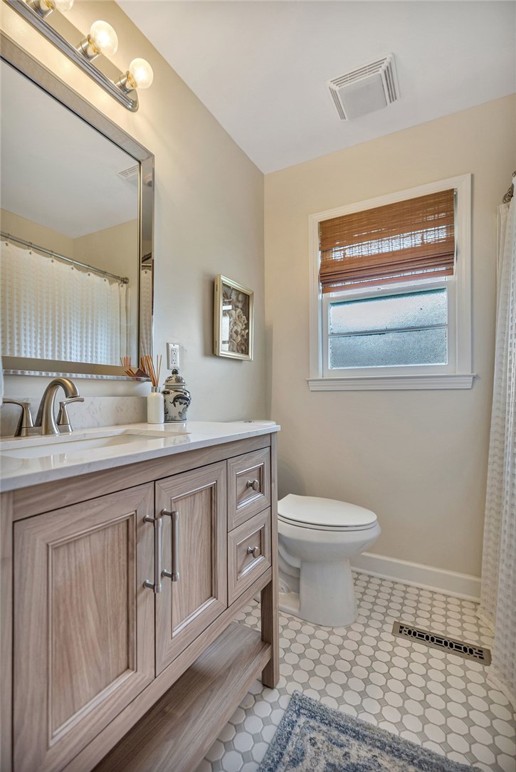 2310 Hannah Road Anderson, SC 29621 - Photo 19 of 32 A refined bathroom featuring a wooden vanity, a large mirror, and hexagonal floor tiling.
