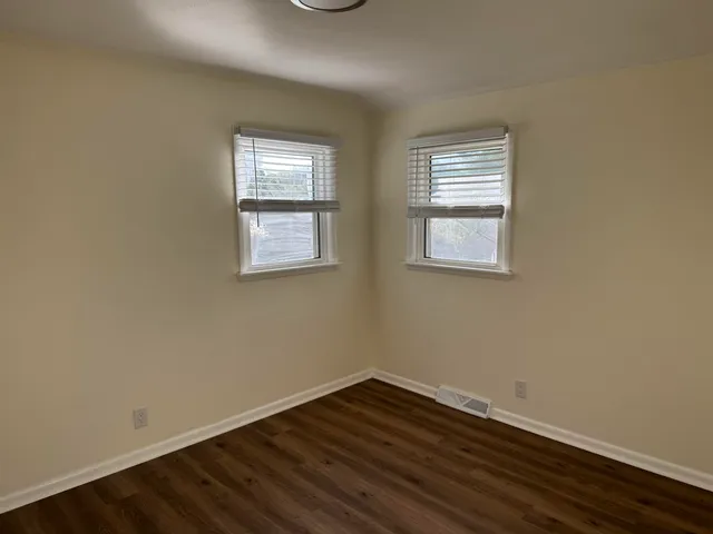 a view of a room with wooden floor and windows