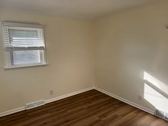 a view of a small space with wooden floor and a window