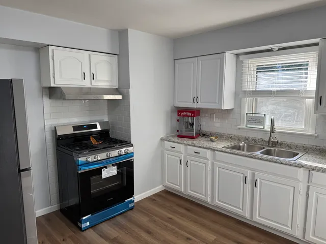 a kitchen with granite countertop a stove sink and cabinets